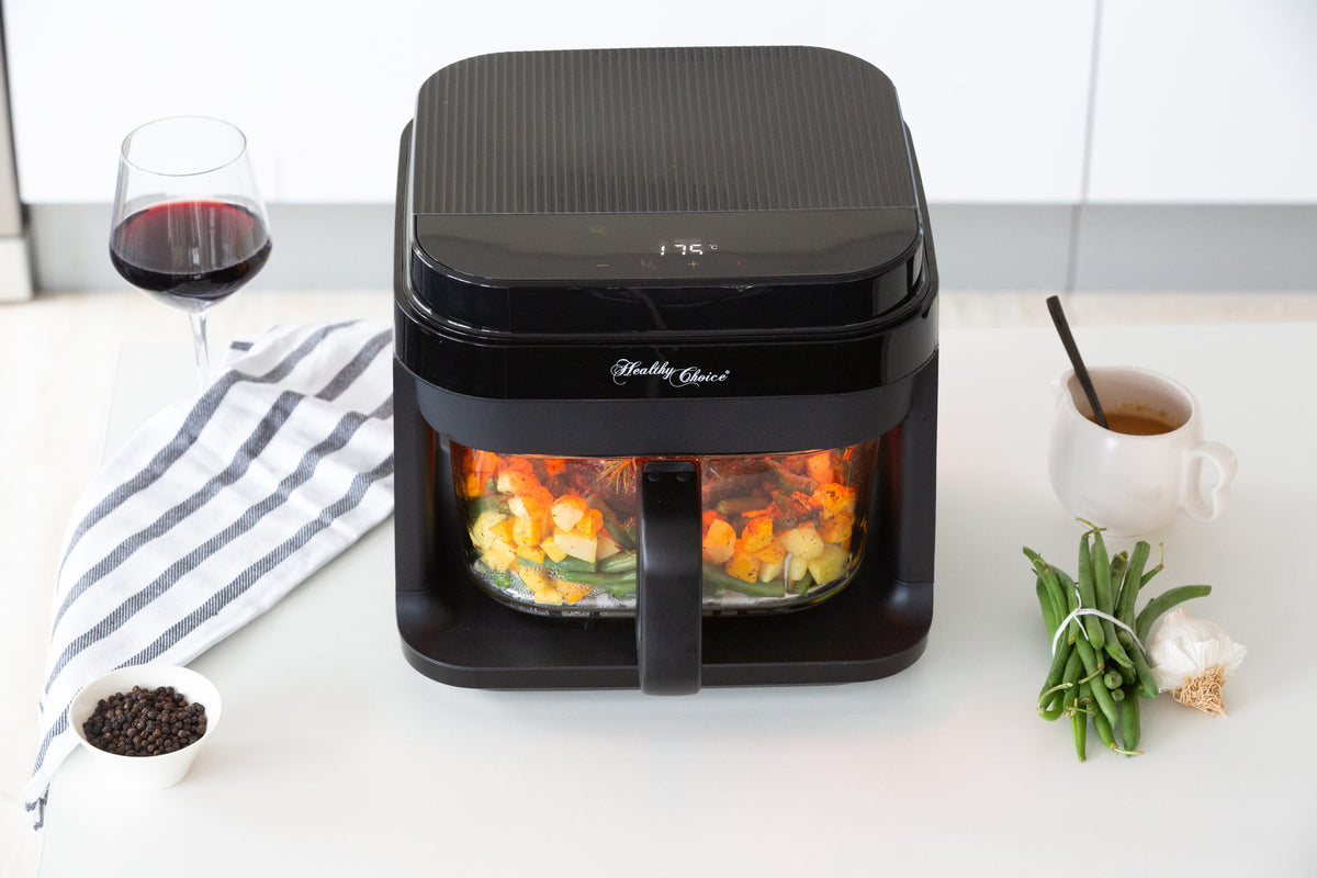 Top view of the AFG605 glass airfryer with control panel on top and roast with veggies visible in the glass cooking basket.