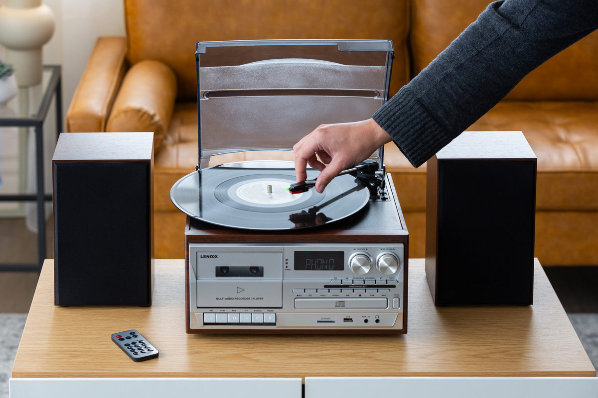Woman's hand moving the tonearm to play a vinyl.
