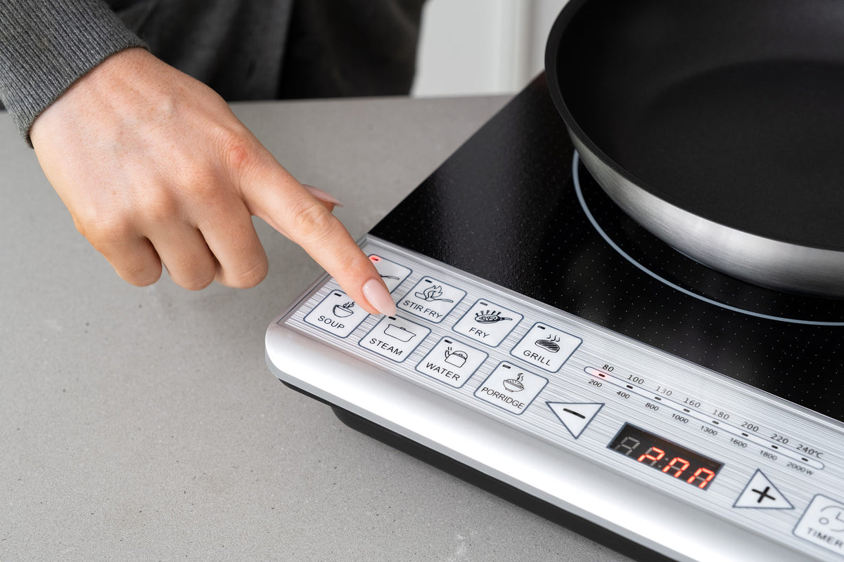 Detail photo of the control panel with woman's finger pointing to the Steam button.