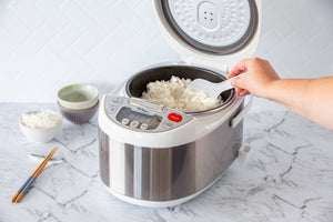 Woman serving rice from the Healthy Choice 5L Electric Rice Cooker in a modern kitchen.