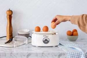 Adding eggs to the Electric Egg Steamer.