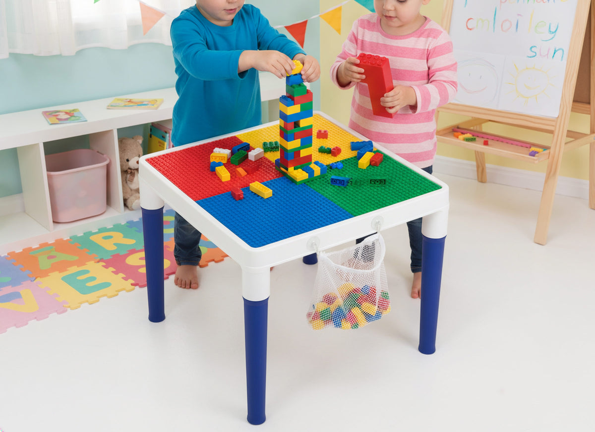 Children playing with colorful building blocks on a multi-colored table in a playroom setting.