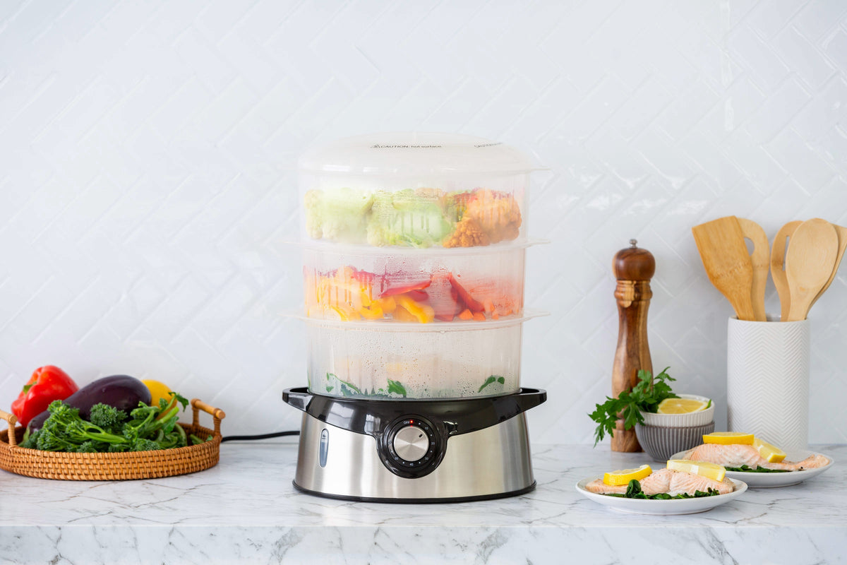 3 Tier Food Steamer in a kitchen, fully loaded with vegetables and fish on all three levels.