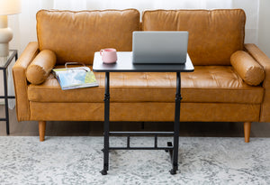 Black Portable Laptop Desk in a modern living room placed in front of a leather couch.