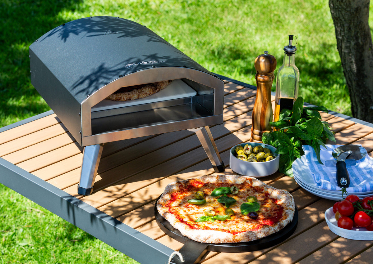 Pizzas baking in the Healthy Choice 12" Electric Pizza Oven in a lush backyard setting.