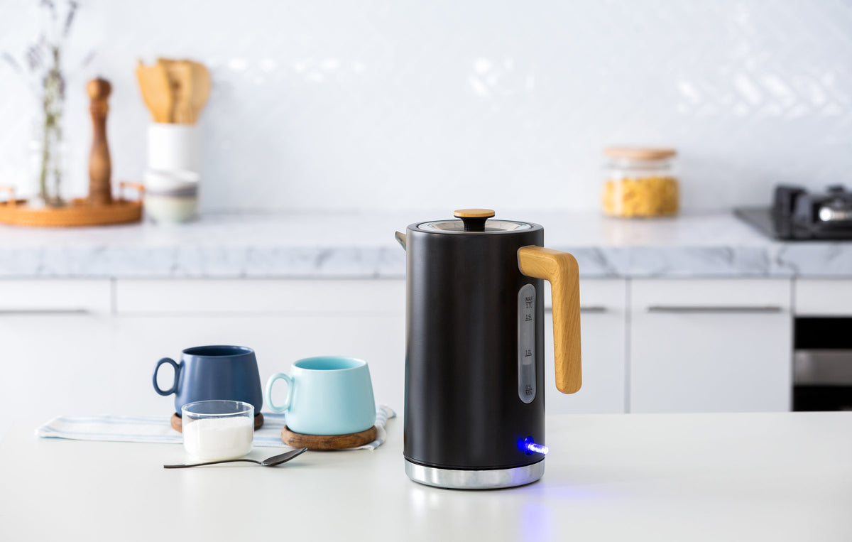 1.7L Kitchen Kettle in Black with Wood Accents with 2 cute mugs next to it in a modern bright kitchen