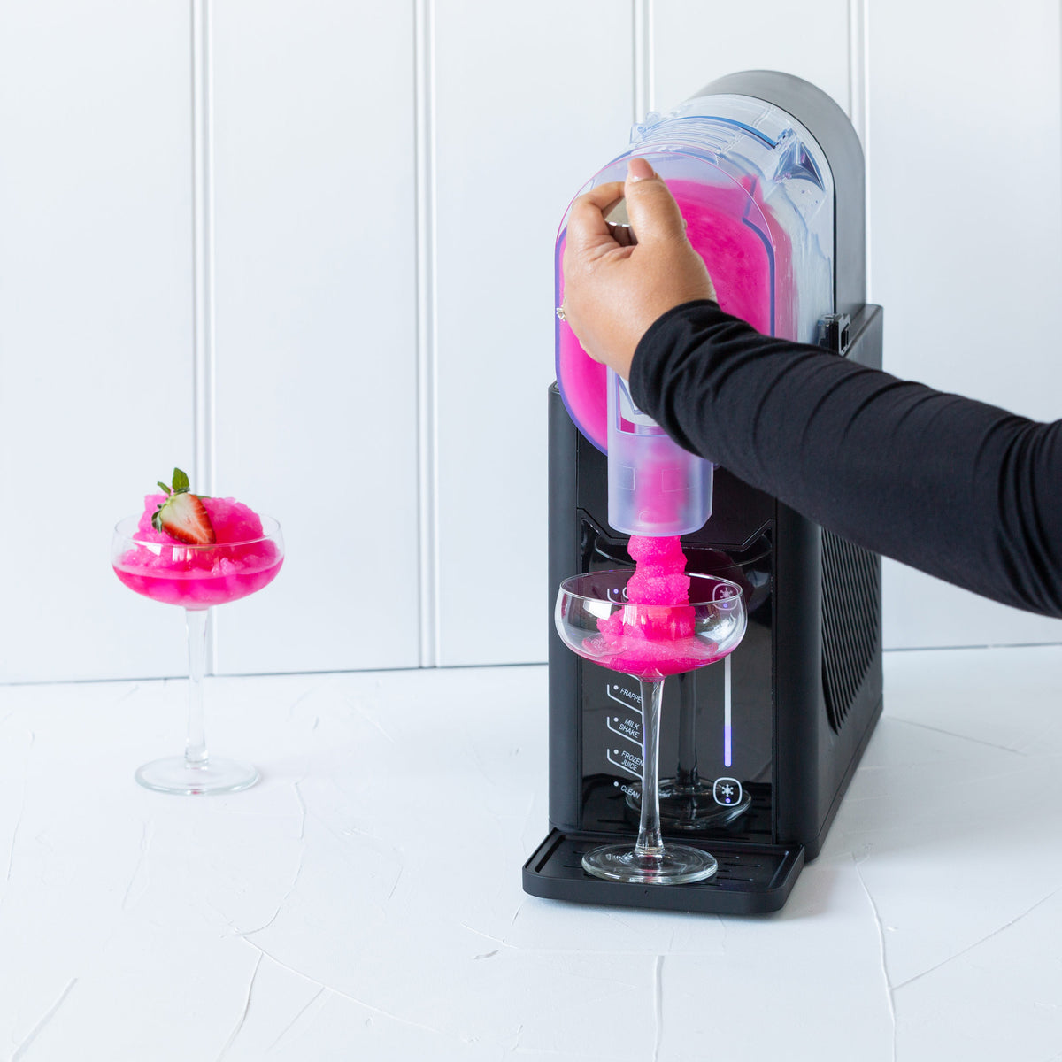Person extracting pink slushie from the SM2000 slushie machine against a white background