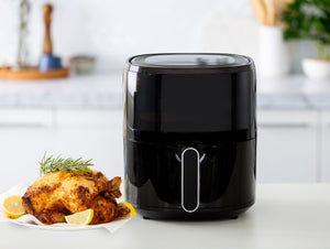 AF605 6L Digital Air Fryer in a modern kitchen with freshly cooked roast chicken next to it.