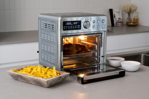 AF1600 16L Stainless Steel Air Fryer Convection Oven  in a modern kitchen with a full chicken inside of it and freshly cooked hot chips in a bowl next to it.