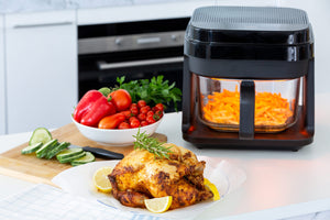 Chips cooking in the 6.5L Digital Air Fryer with glass cooking basket and already air fried whole chicken next to it.