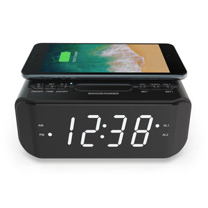 Wireless Qi Phone Charger with FM Radio and clock with a smartphone being charged on top of it.