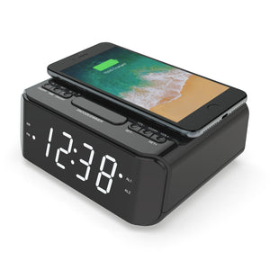 Angle view of the wireless Qi Phone Charger with FM Radio and clock with a smartphone being charged on top of it.
