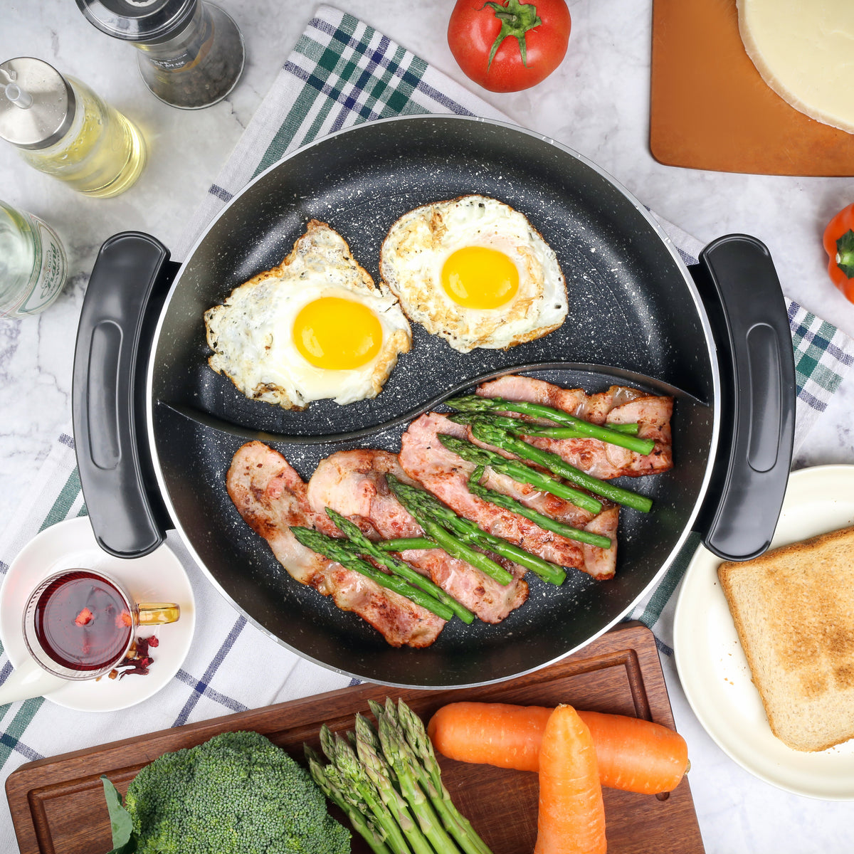 Electric Fry Pan with Cooking Divider eggs are fried on one side while bacon and asparagus are on the other.