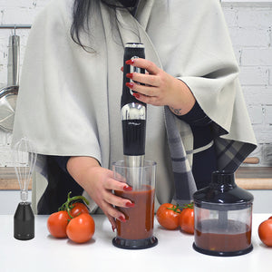 Woman blending tomatoes in the cordless stick hand blender.