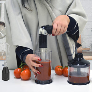 Woman blending tomatoes in the cordless stick hand blender.