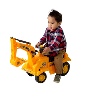 Little boy sitting happily on the yellow ride-on toy excavator.
